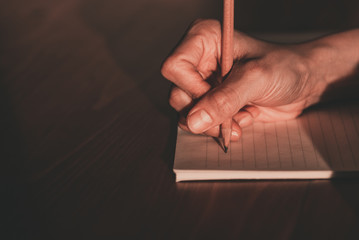 Close up of  people hand  writing on notebook