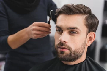 Papier Peint photo Salon de coiffure Handsome guy getting haircut by barber