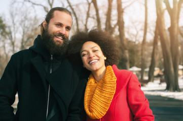 Romantic multiethnic couple in love hugging on the street