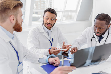 Serious doctors analyzing radiograph on council