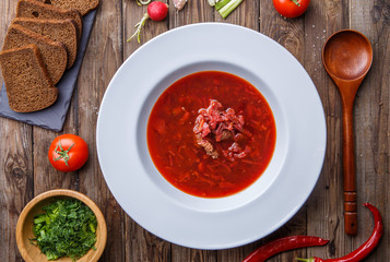 Beet soup in white plate with vegetables