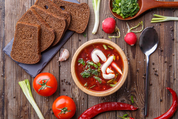Beet soup in wooden plate with vegetables