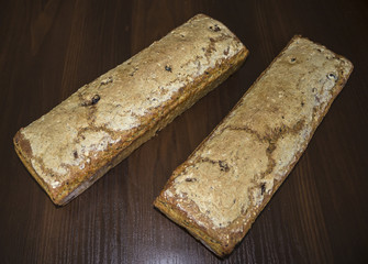 Two loaves of bread baked at home. Polish cuisine. Bread from rye with additives on a dark background..