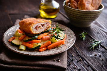 Chicken breasts chops stuffed with English bacon and Edam cheese, served, with steamed vegetable