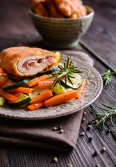 Chicken breasts chops stuffed with English bacon and Edam cheese, served, with steamed vegetable
