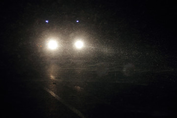Машина едет ночью видно фары идёт снег