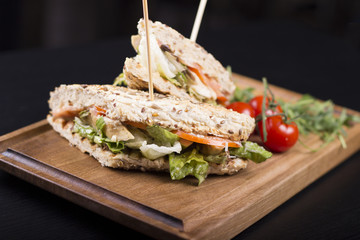 Meat sandwiches with lettuce, tomatoes, and french fries on the side. Beautifully served meal at the restaurant.
