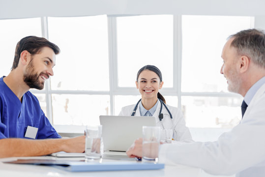 Cheerful doctors discussing human health with satisfaction