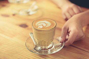 Glass of tasty latte is on timbered surface
