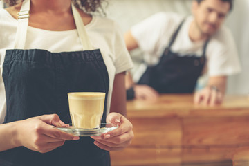 Attractive worker holding glass of tasty coffee