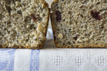 Two piece of homemade bread with cranberries . The Polish kitchen. Brown bread made from rye on a light background. .