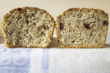 Two piece of homemade bread with cranberries . The Polish kitchen. Brown bread made from rye on a light background. .