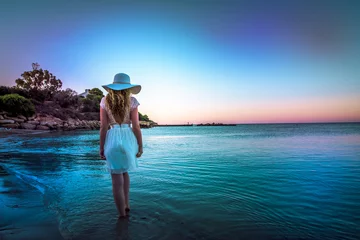 Poster Woman walking down the beach at sunset. Beautiful Sunset sea view in Cyprus island © castecodesign