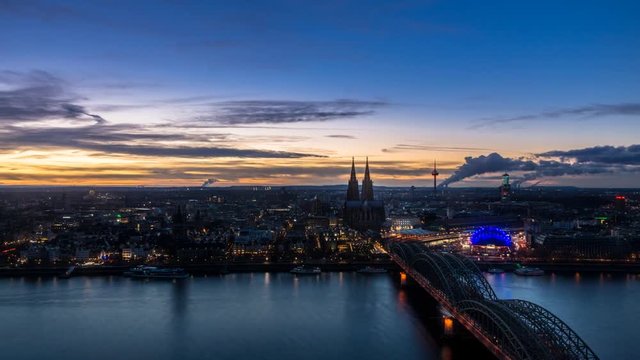 Beautiful sunset turning into blue hour above Cologne. Aerial view of the Cathedral - Dom and Hohenzollern bridge