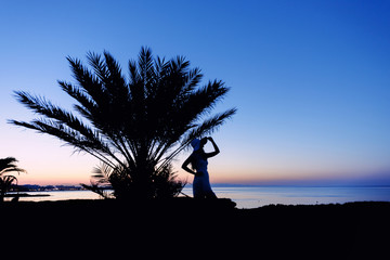 Girl silhouette at sunset. Beautiful sea view at sunset. Tropic Island. Cyprus Protaras