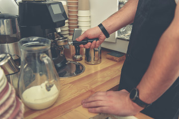 Fototapeta na wymiar Male barista preparing americano in cafe