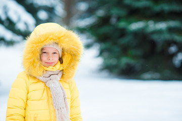 Portrait of little adorable girl with beautiful green eyes in snow sunny winter day