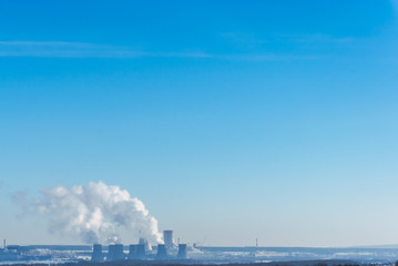 Naklejka premium Nuclear power plant on the sky background. Cooling towers of NPP with smoke. 