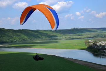 Paragliding over river valley in the summer sunny day. Dniester river, Ukraine