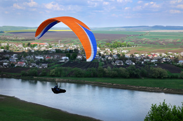 Paragliding over river valley in the summer sunny day. Dniester river, Ukraine