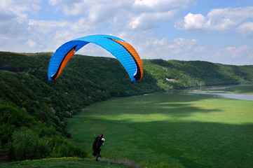 Paragliding over river valley in the summer sunny day. Dniester river, Ukraine