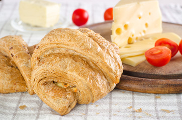 Early morning reakfast with croissant, cheese and tomatoes.