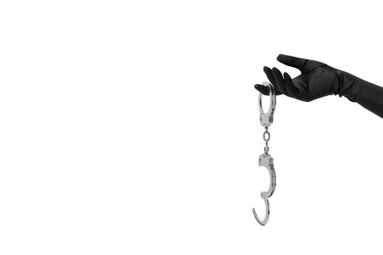 Mit schwarzem Handschuh bekleidete Damenhand lockt mit Handschellen