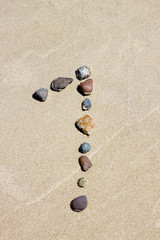 Fototapeta na wymiar Number one made of stones on the sand