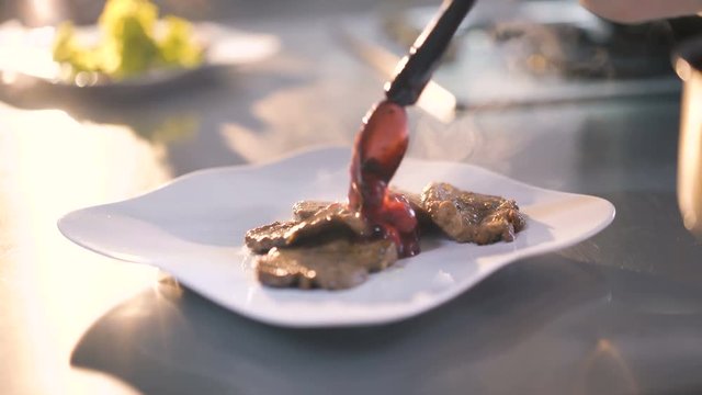 Master chief pouring gravy on meat's dish in 4K