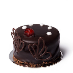 Round chocolate cake with white and berry decoration isolated. Dessert on a white background