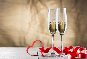 two champagne glasses with red ribbon heart shape .valentines da