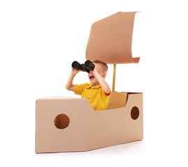 Little boy playing with cardboard ship isolated on white
