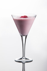 Raspberry vodka cocktail with cranberry juice, vanilla ice cream and raspberries. On white background with reflection.