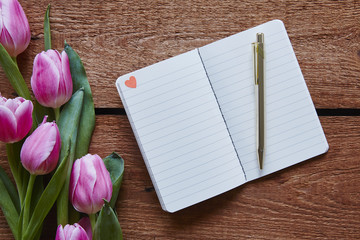 Naklejka premium notebook with little heart tulips in vivid atmosphere