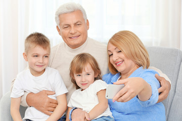 Obraz premium Happy family taking selfie on couch