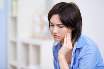 Beautiful young woman suffering from toothache at home