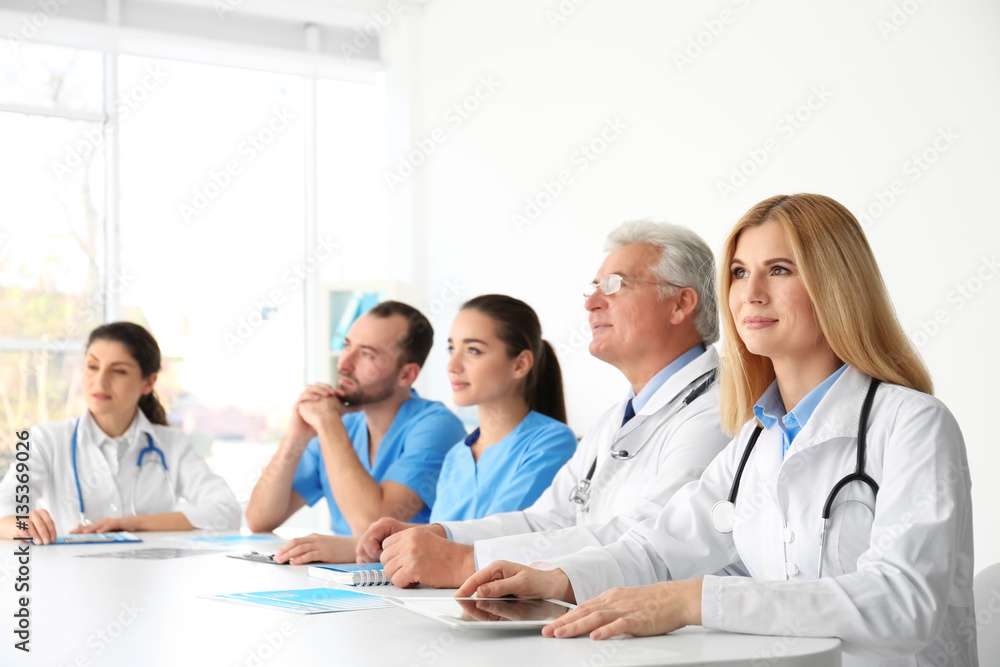 Poster Team of doctors sitting at table in clinic