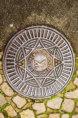 Fonderie de Luxembourg translating as Luxembourg Foundry - manhole cover surrounded by old cobblestone 