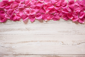 Wooden background with rose petals