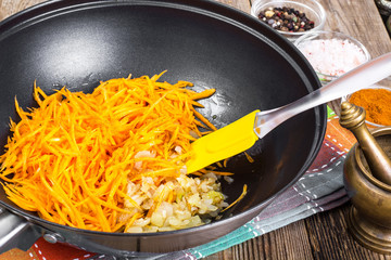 Grated pumpkin with chopped onion in a frying pan