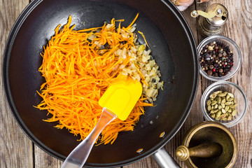 Grated pumpkin with chopped onion in a frying pan