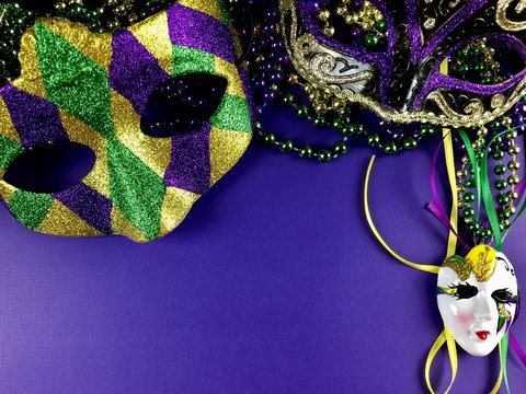 Mardi Gras mask and beads on a purple background 