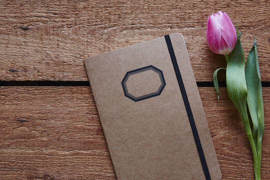 a retro notebook and a tulip spring atmosphere on wooden desk
