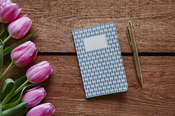 pen and diary ready to write spring atmosphere with pink tulips