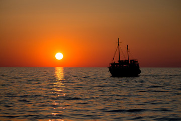 Fototapeta premium Sonnenuntergang im Meer mit Piratenboot
