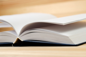 Open book on wooden table.