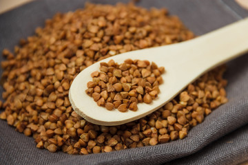 buckwheat grains and wooden spoon