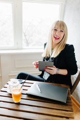 Smiling businesswoman about to pay the bill.