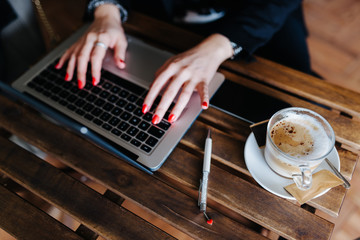 Fototapeta na wymiar Business woman typing her report in a coffeeshop.