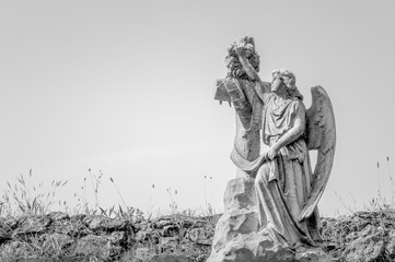 Estatua de ángel de una tumba en cementerio